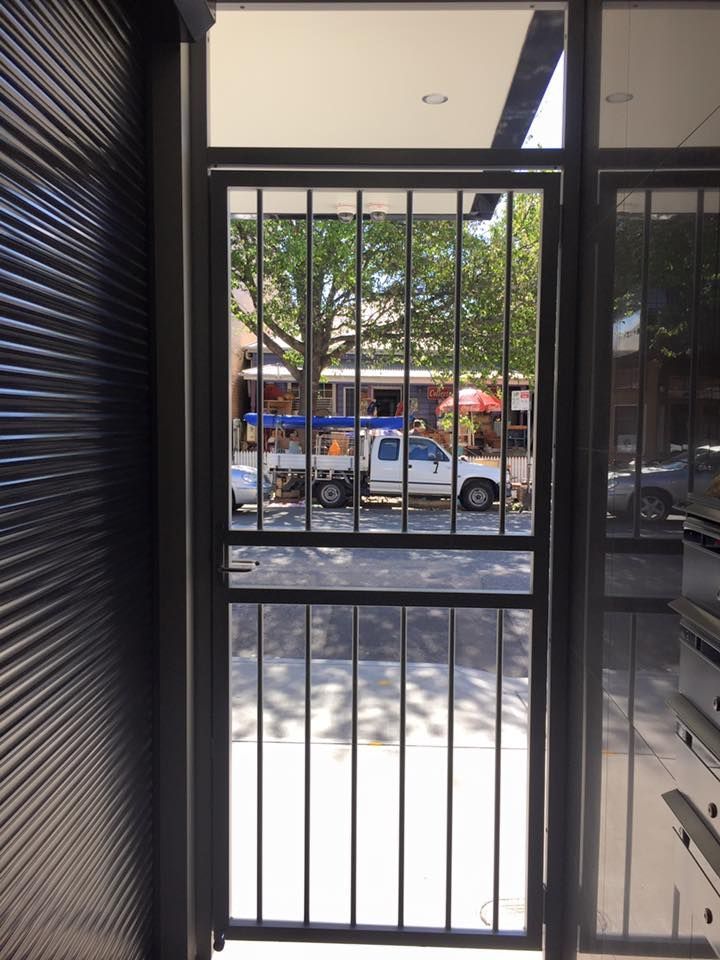 A white truck is parked behind a metal gate