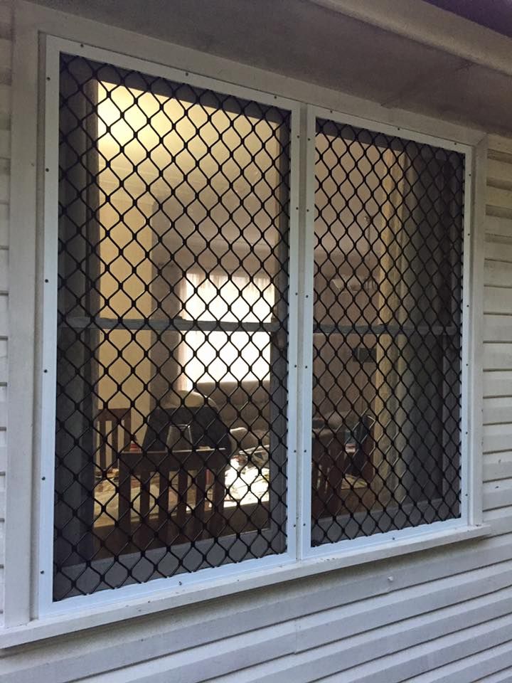 A white house with a window with a fence around it