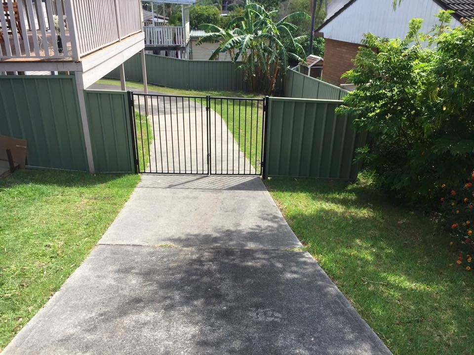 A driveway with a gate leading to a house