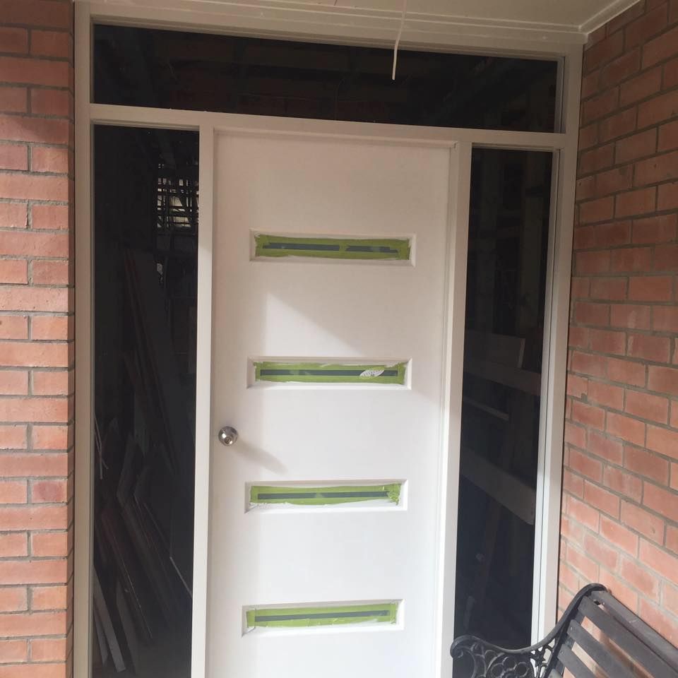 A white door is sitting on a brick wall next to a bench.