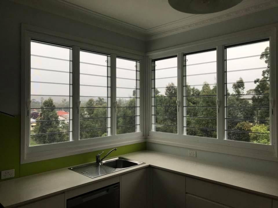 A kitchen with a sink and a lot of windows.