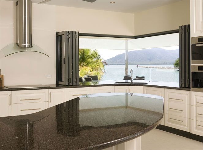 A kitchen with a large window and a black counter top