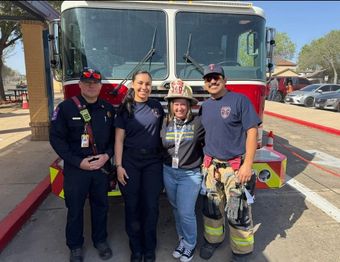 A group of firefighters posing in front of a fire truck