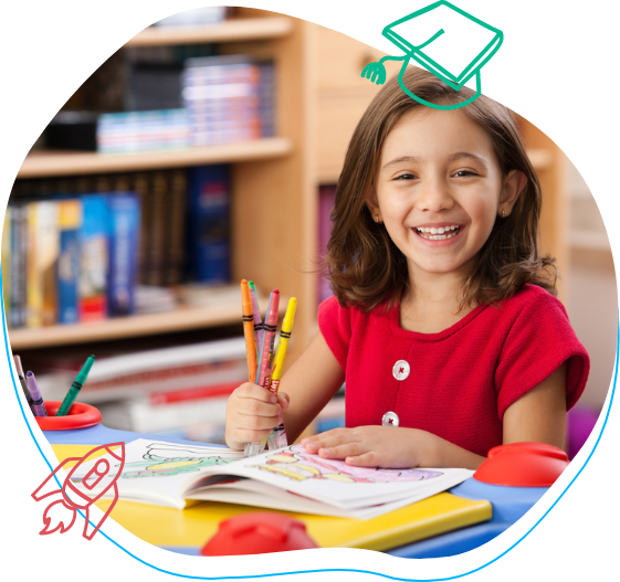 a little girl in a red shirt is sitting at a table with crayons and a book
