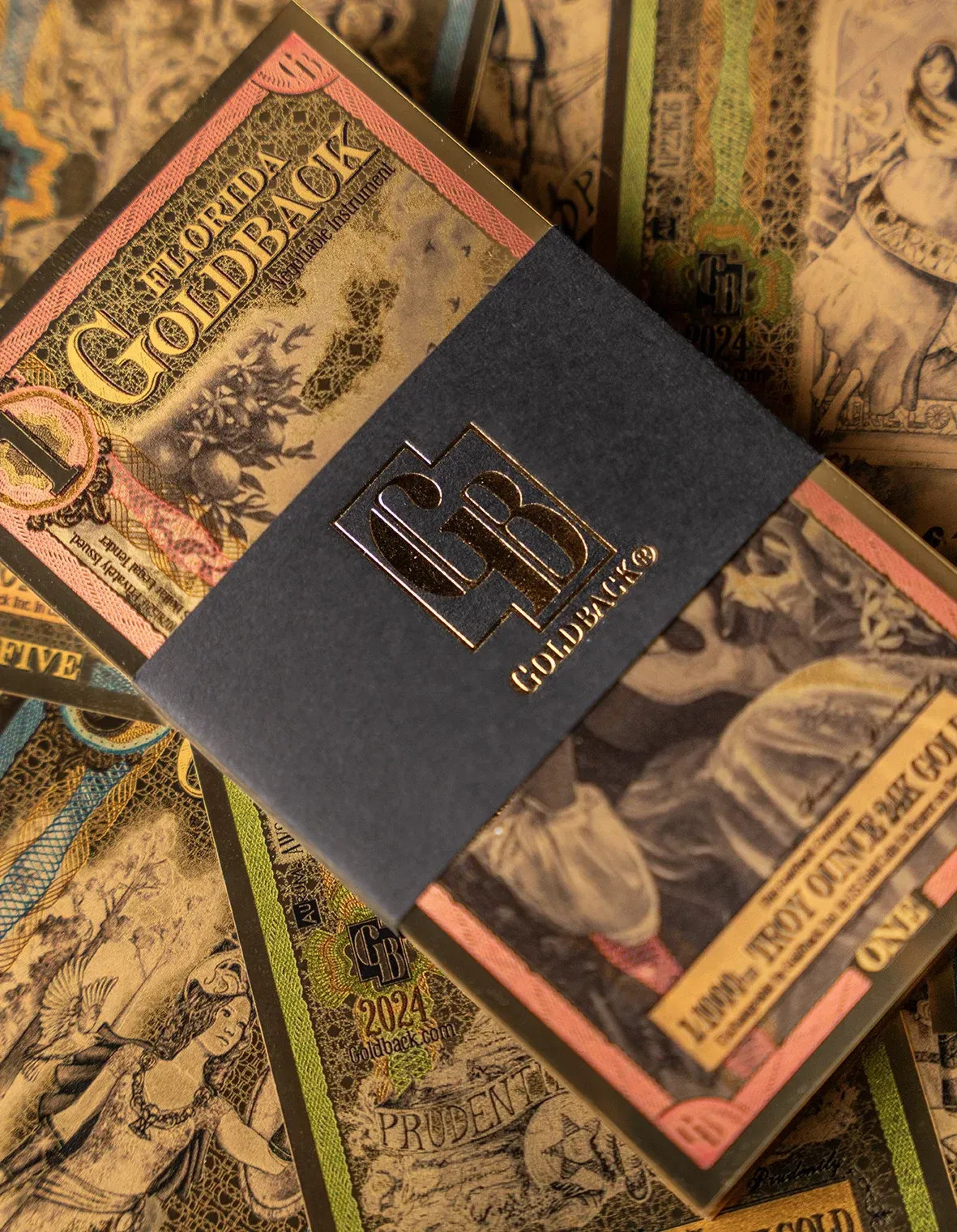 Stack of gold-toned playing cards, bound by a black band with gold lettering.