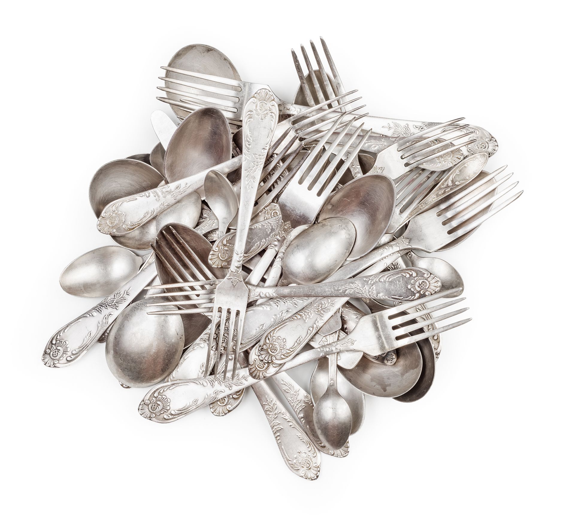 Pile of tarnished silver forks and spoons on a white background.