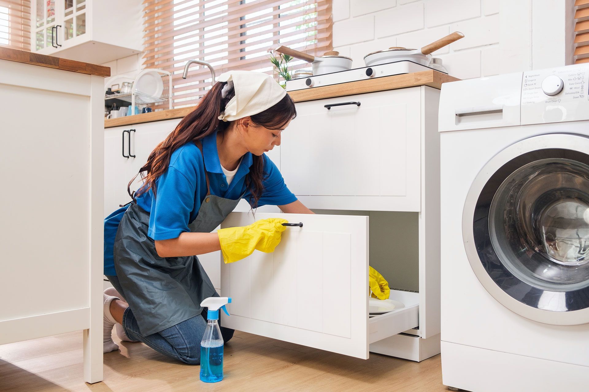 Woman cleaning a kitchen cabinet