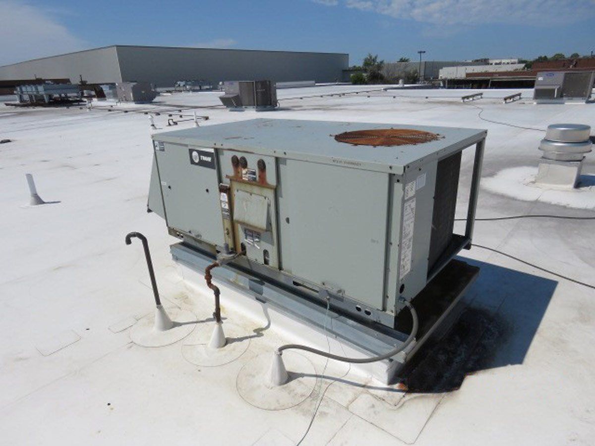 Heating and air conditioning unit on top of an apartment that is aging and has concerning rust on exterior parts