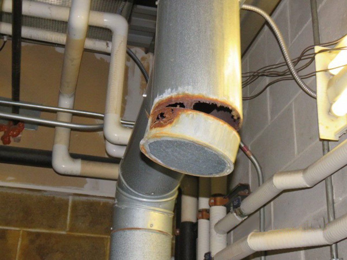 Metal water heating vent with so much corrosive rust that the bottom end is cracking off