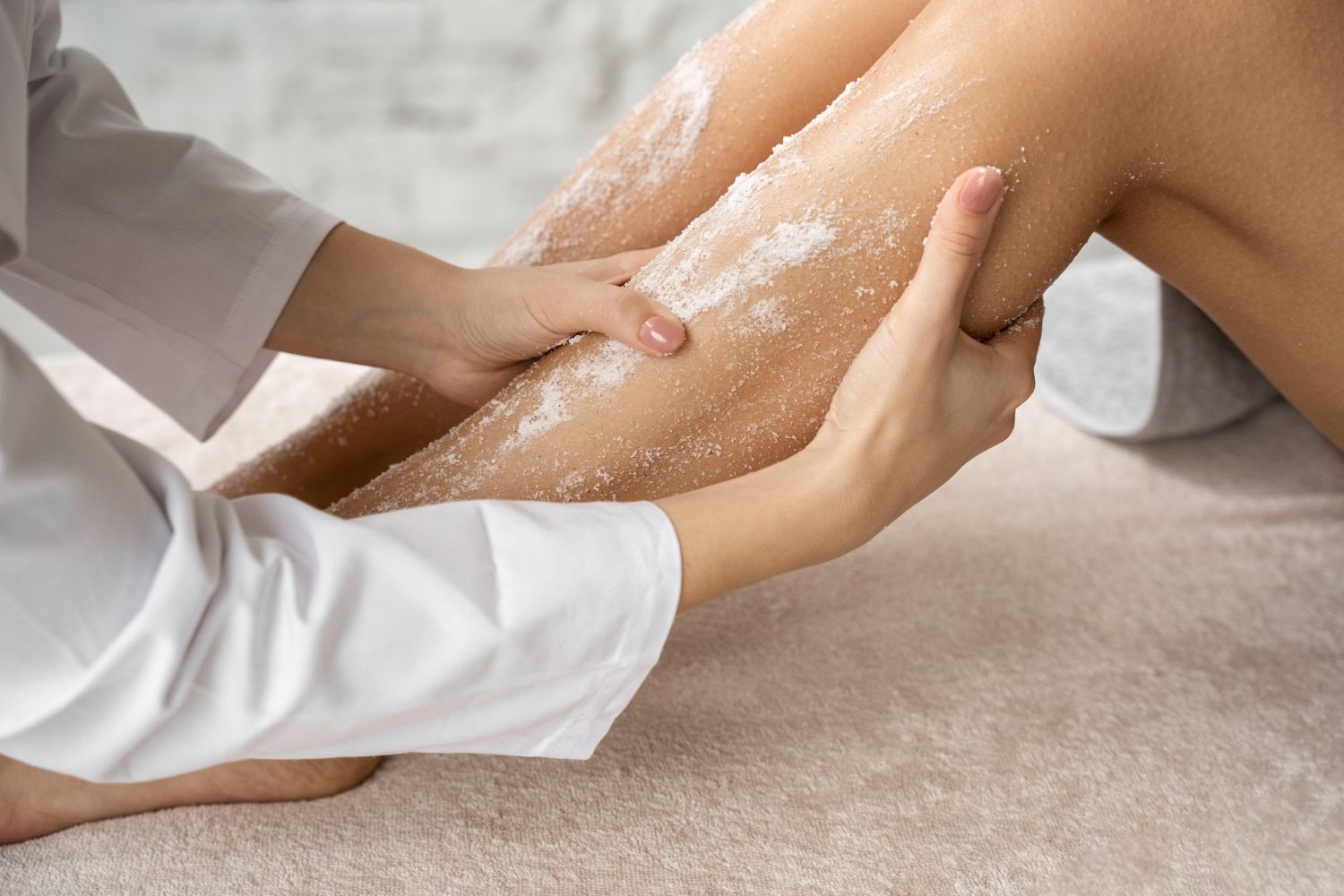A woman is getting a leg scrub at a spa.