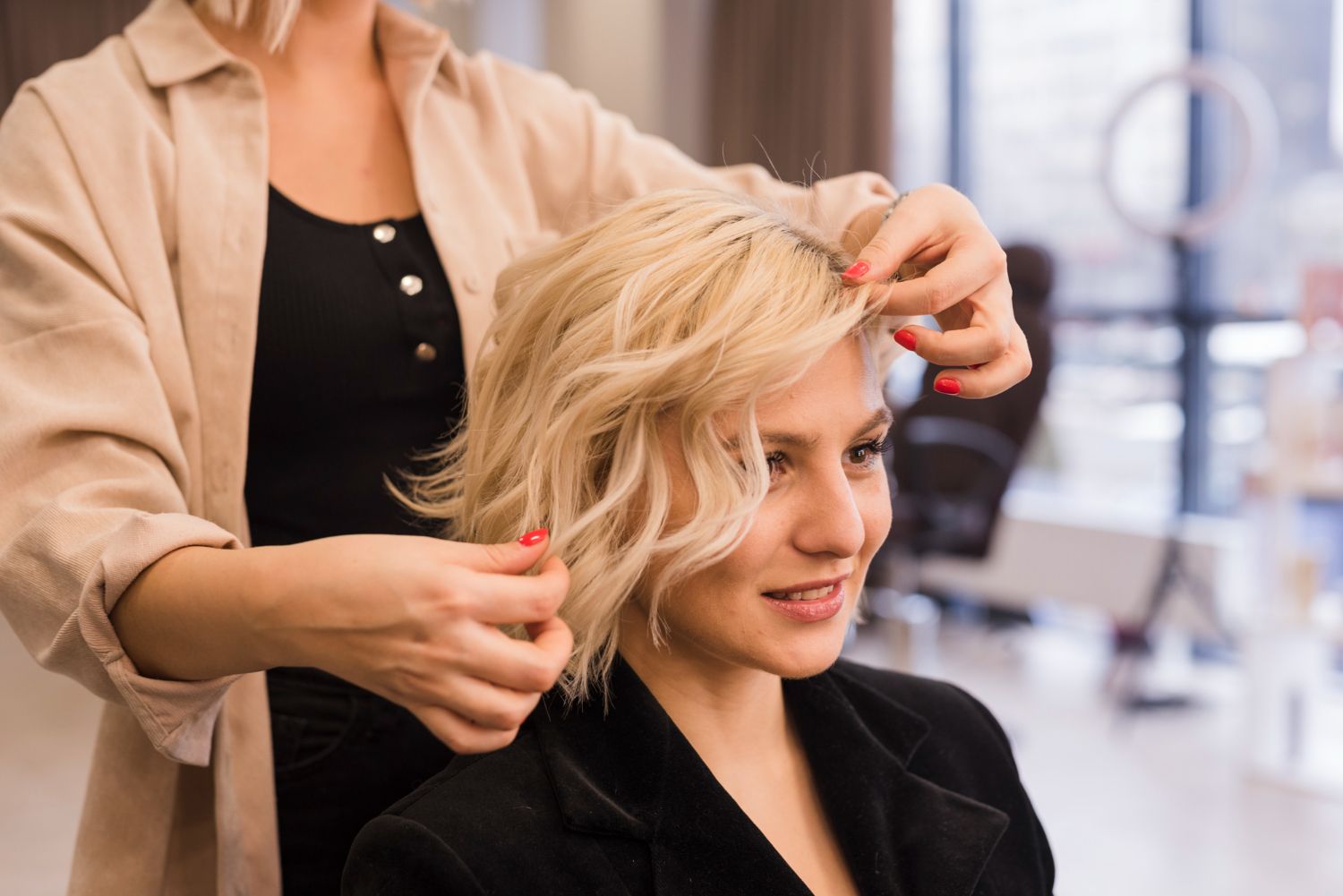 A woman is getting her hair cut by a hairdresser in a salon.