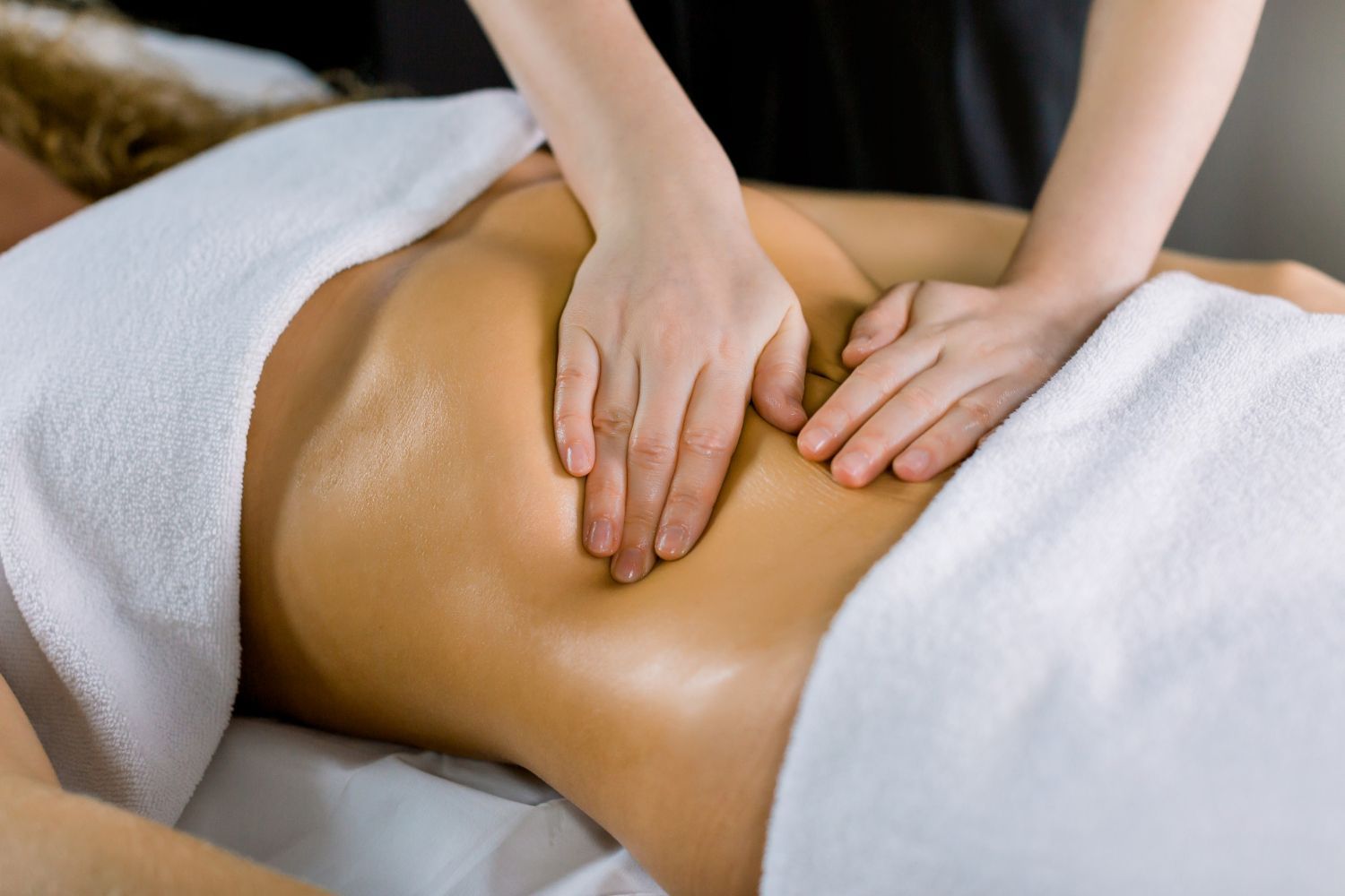 A woman is getting a massage on her stomach at a spa.