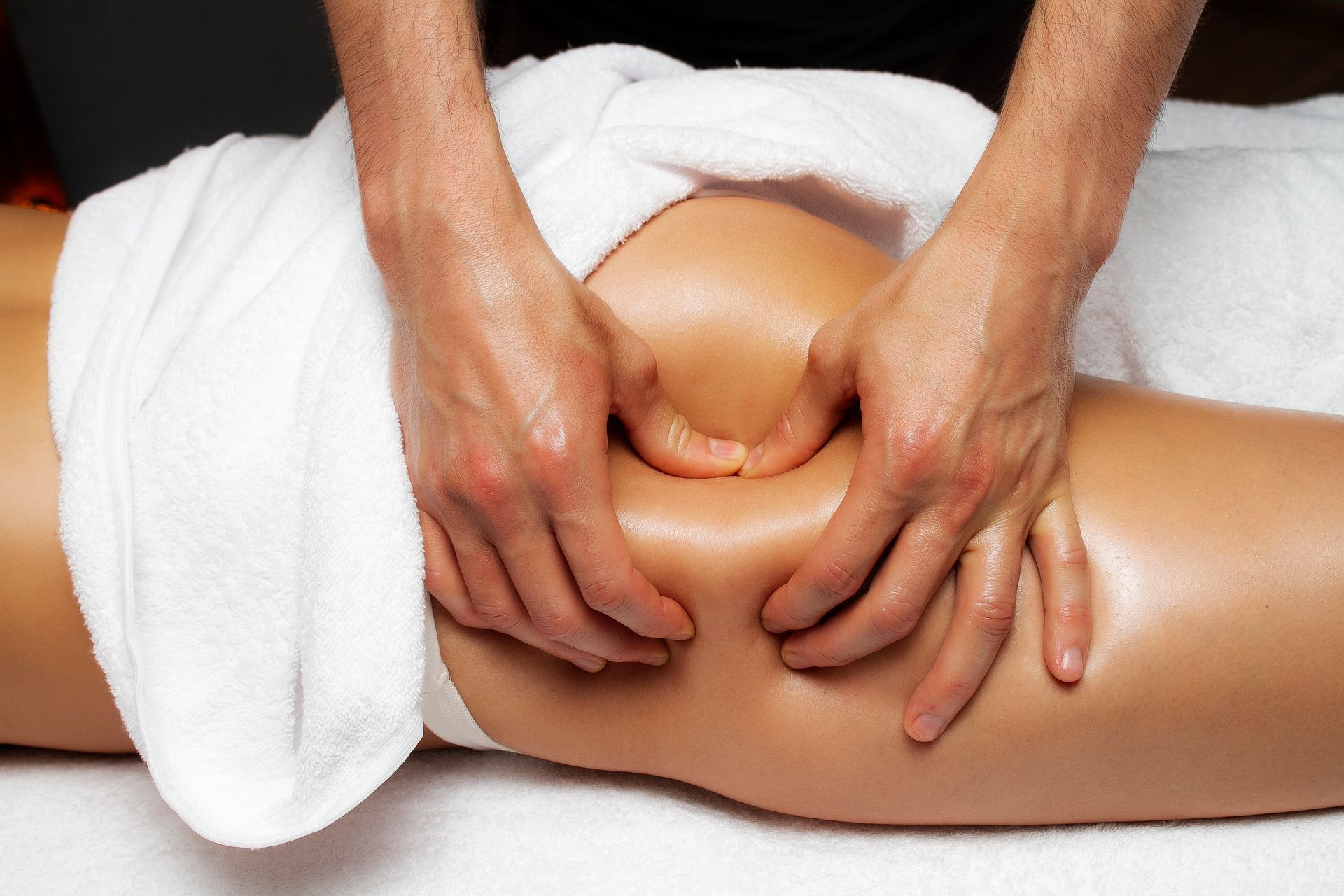 A woman is getting a massage on her leg in a spa.