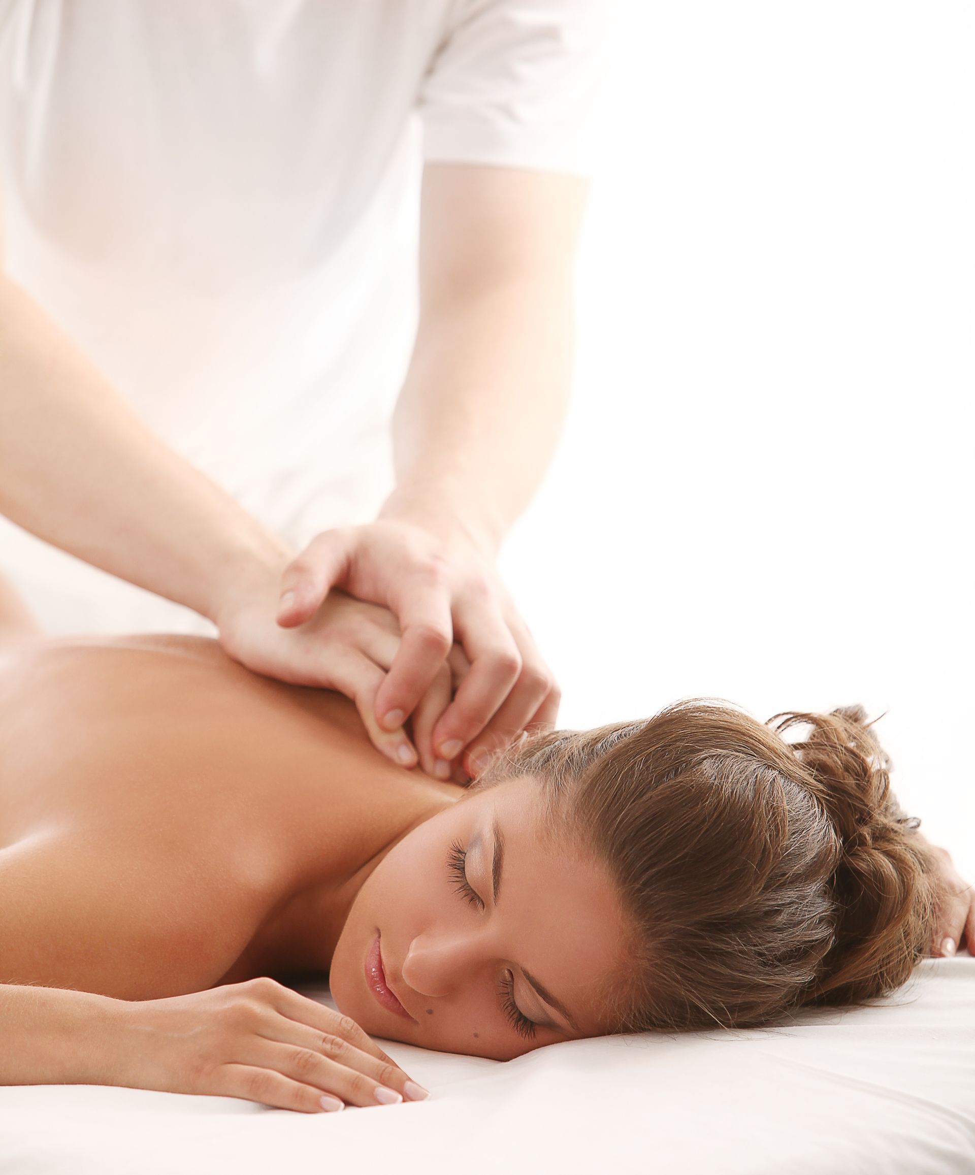 a woman is laying on a bed getting a massage