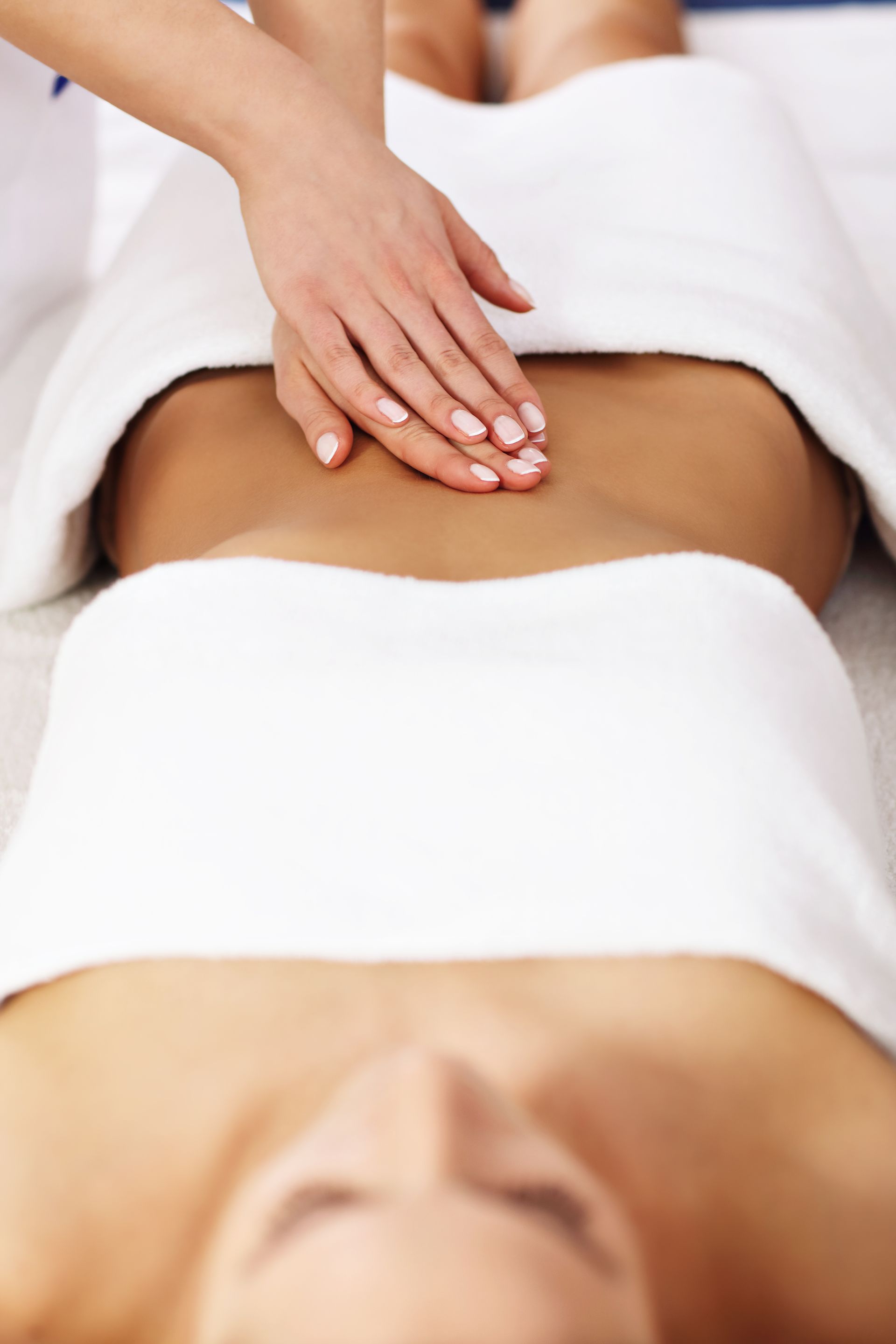 A woman is getting a massage on her stomach at a spa.