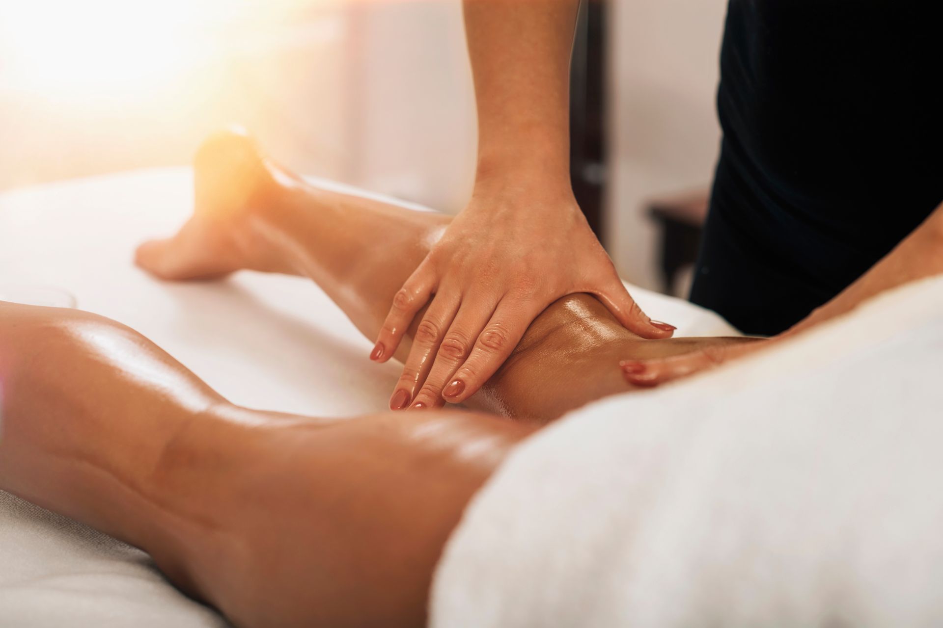 A woman is getting a massage on her leg in a spa.