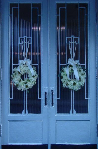 a pair of doors with wreaths on them