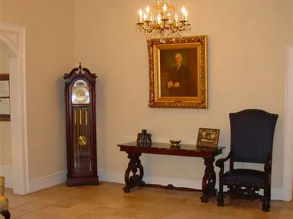 a room with a clock and a painting on the wall