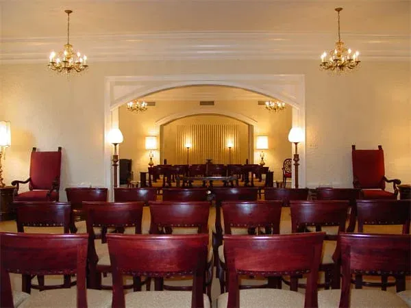 rows of wooden chairs are lined up in a room