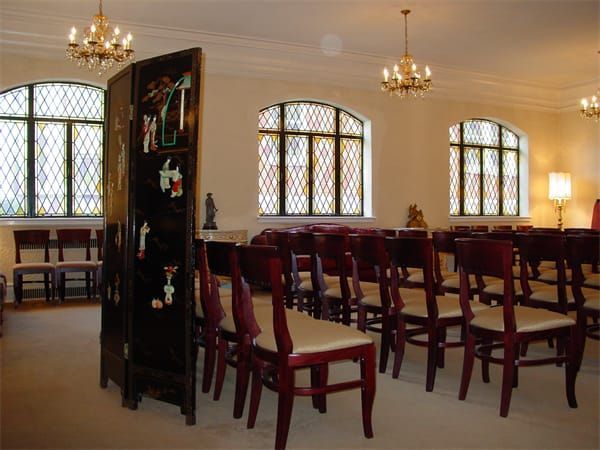 rows of chairs in a room with stained glass windows