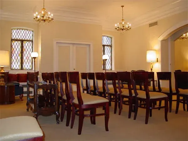 a row of chairs in a room with stained glass windows