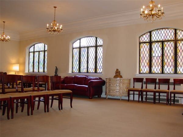 a room with a couch and chairs and stained glass windows