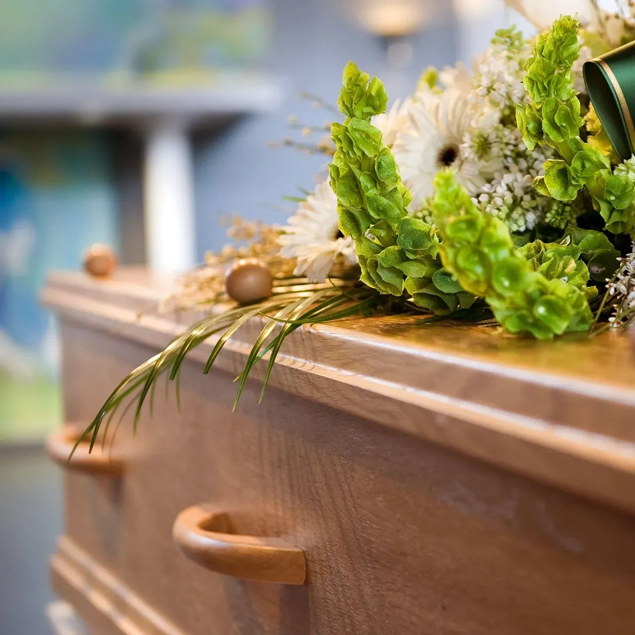 Boquete of flowers sitting on top of a wooden casket
 