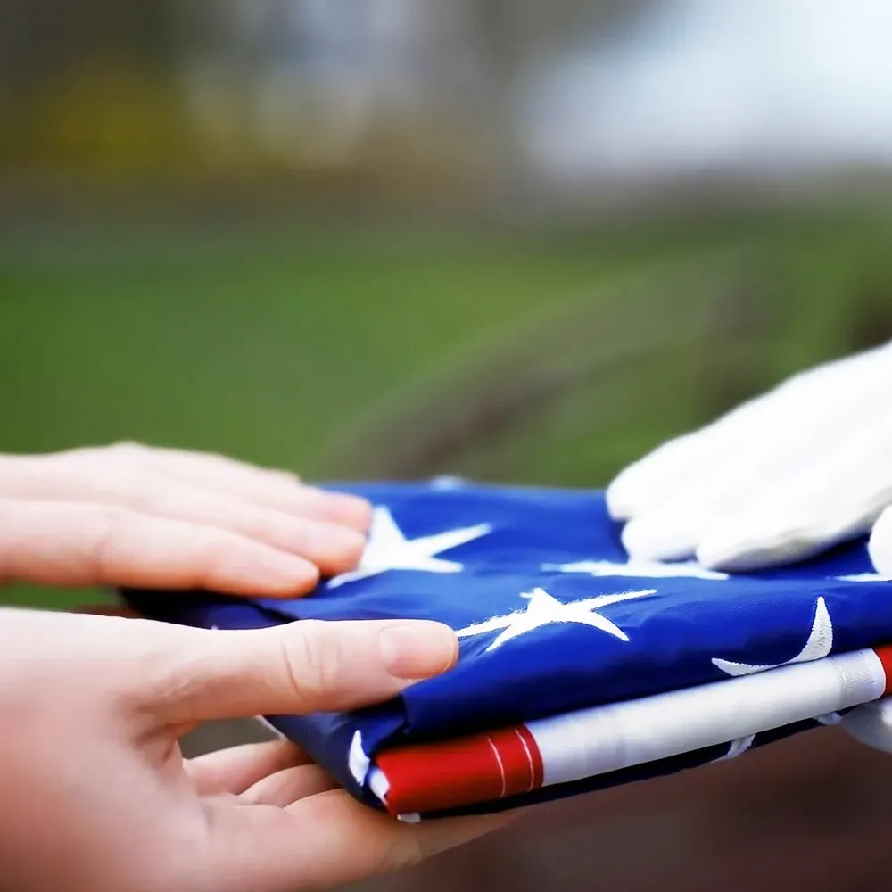 a person is handing an american flag to another person