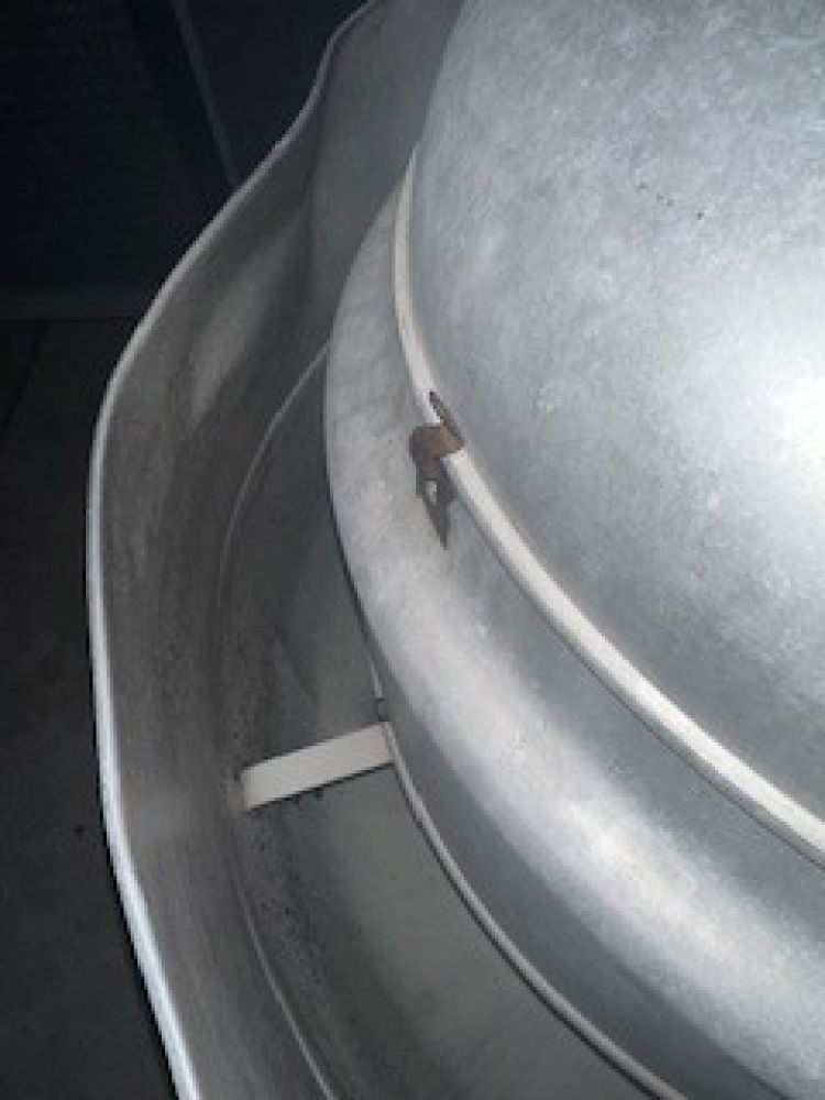 Stainless steel commercial kitchen exhaust hood. Angled view of the vent with metal slats.