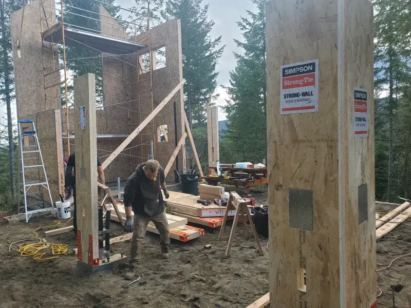 A man is standing in front of a building under construction.