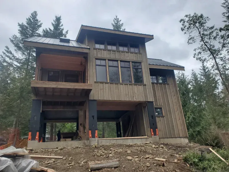 A large house is being built in the middle of a forest.