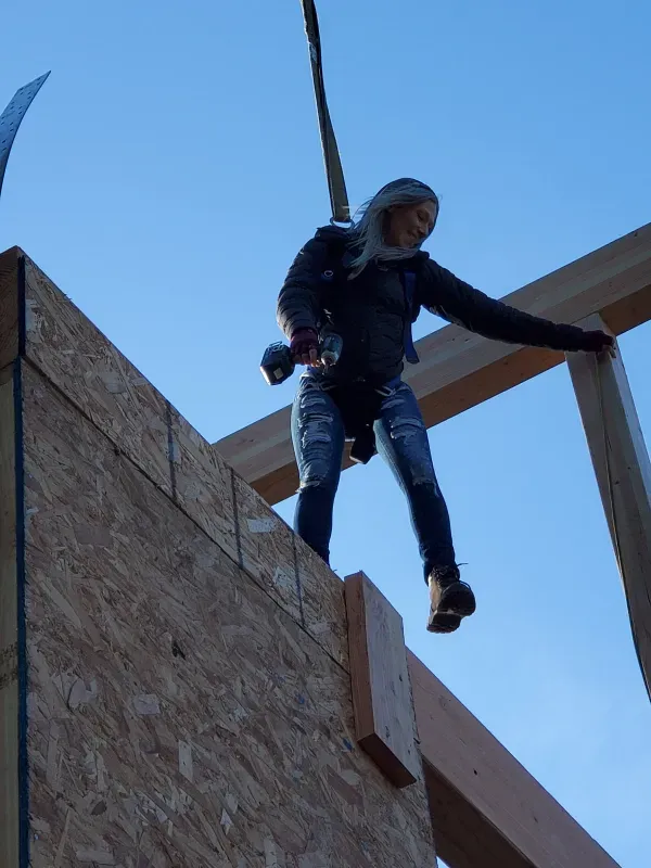 A woman is standing on top of a wooden structure