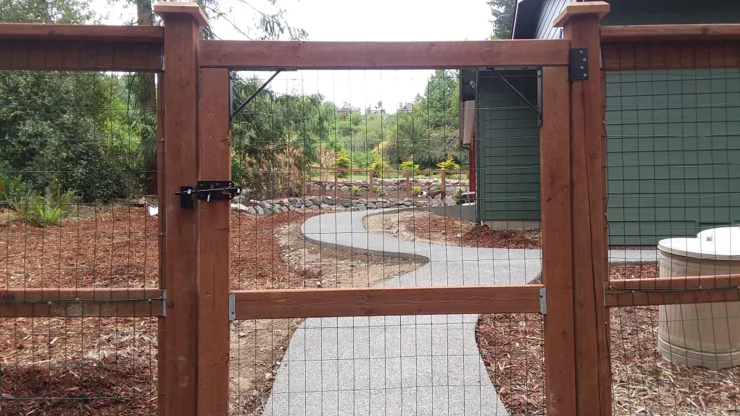 A wooden fence with a gate leading to a path.