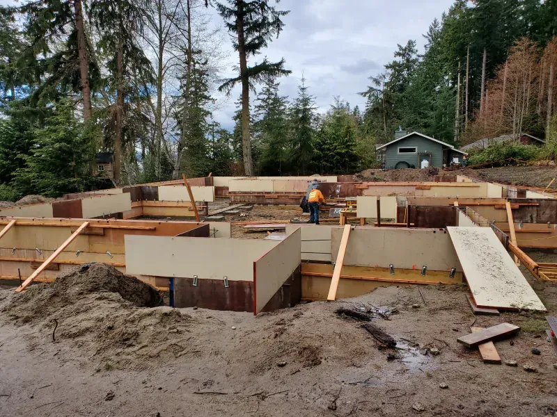 A man is standing in the middle of a construction site.