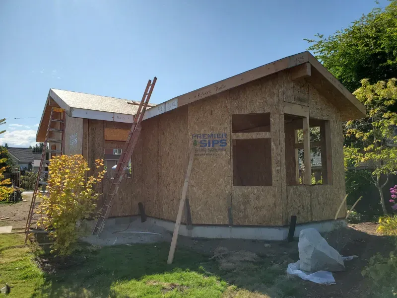 A small house is being built with sips on the side