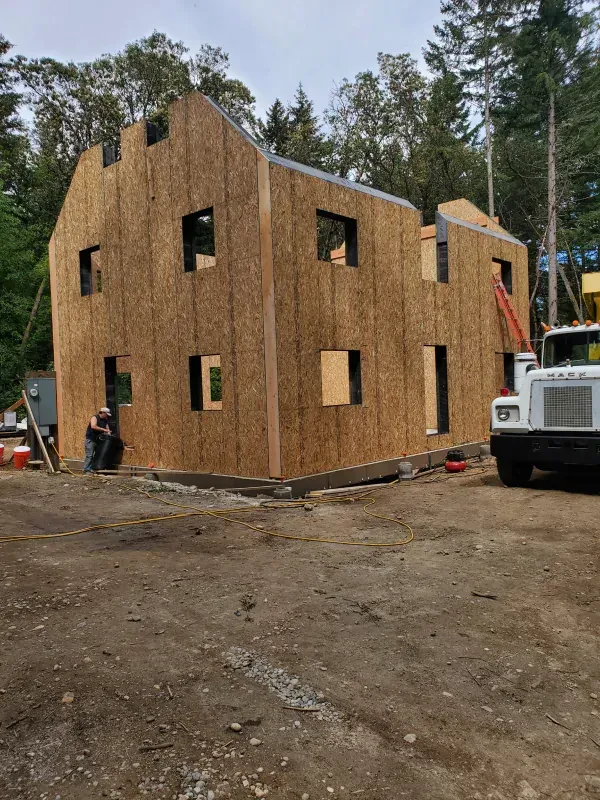 A truck is parked in front of a building under construction.
