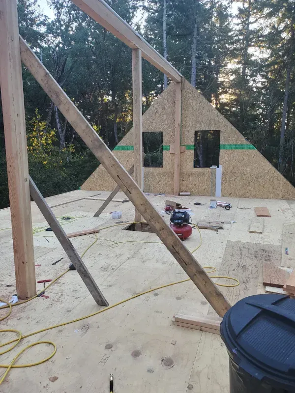 A wooden structure is being built in the middle of a forest.