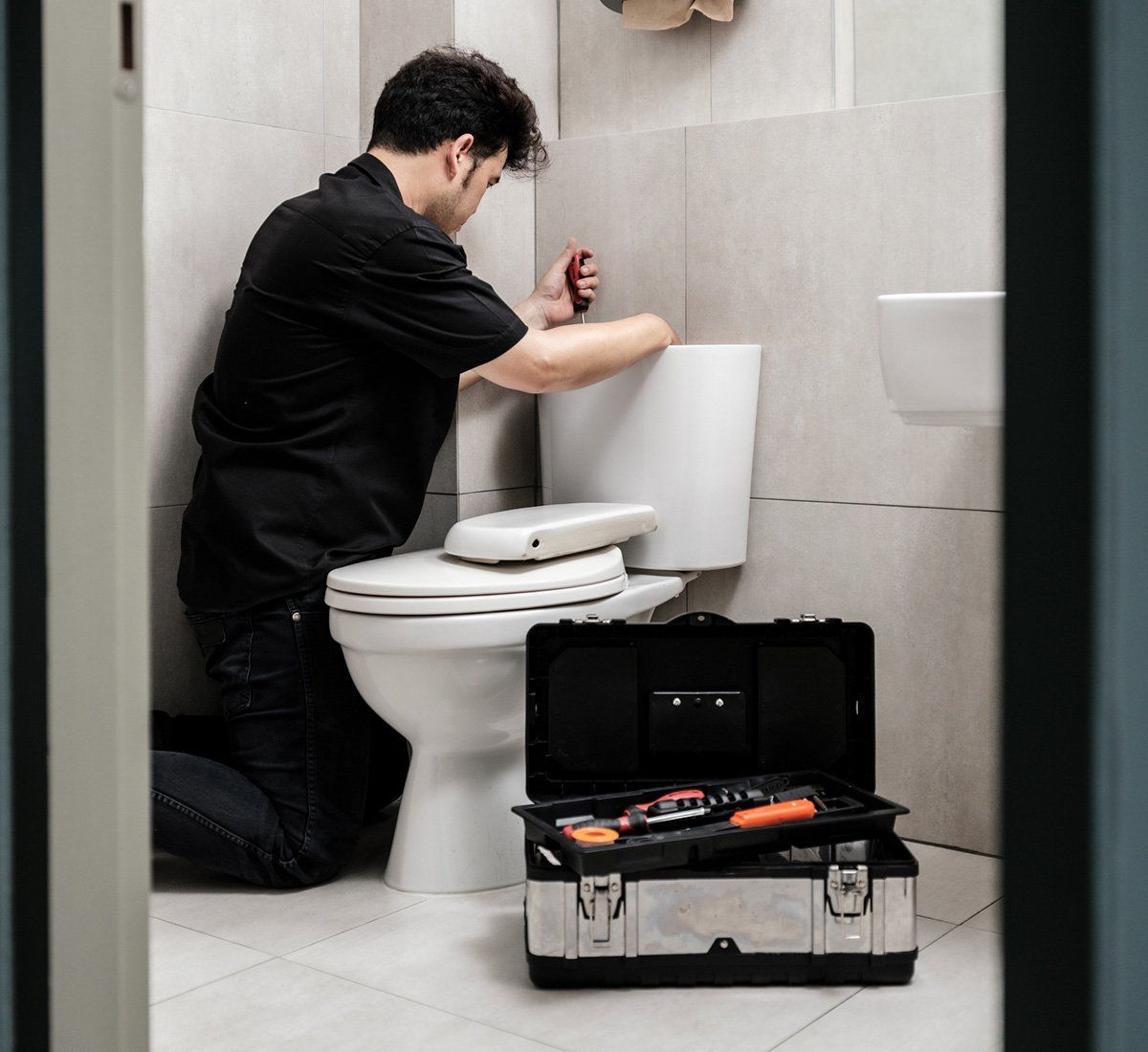 Man Fixing the Toilet — Opelika, AL — Roto-Rooter - Opelika