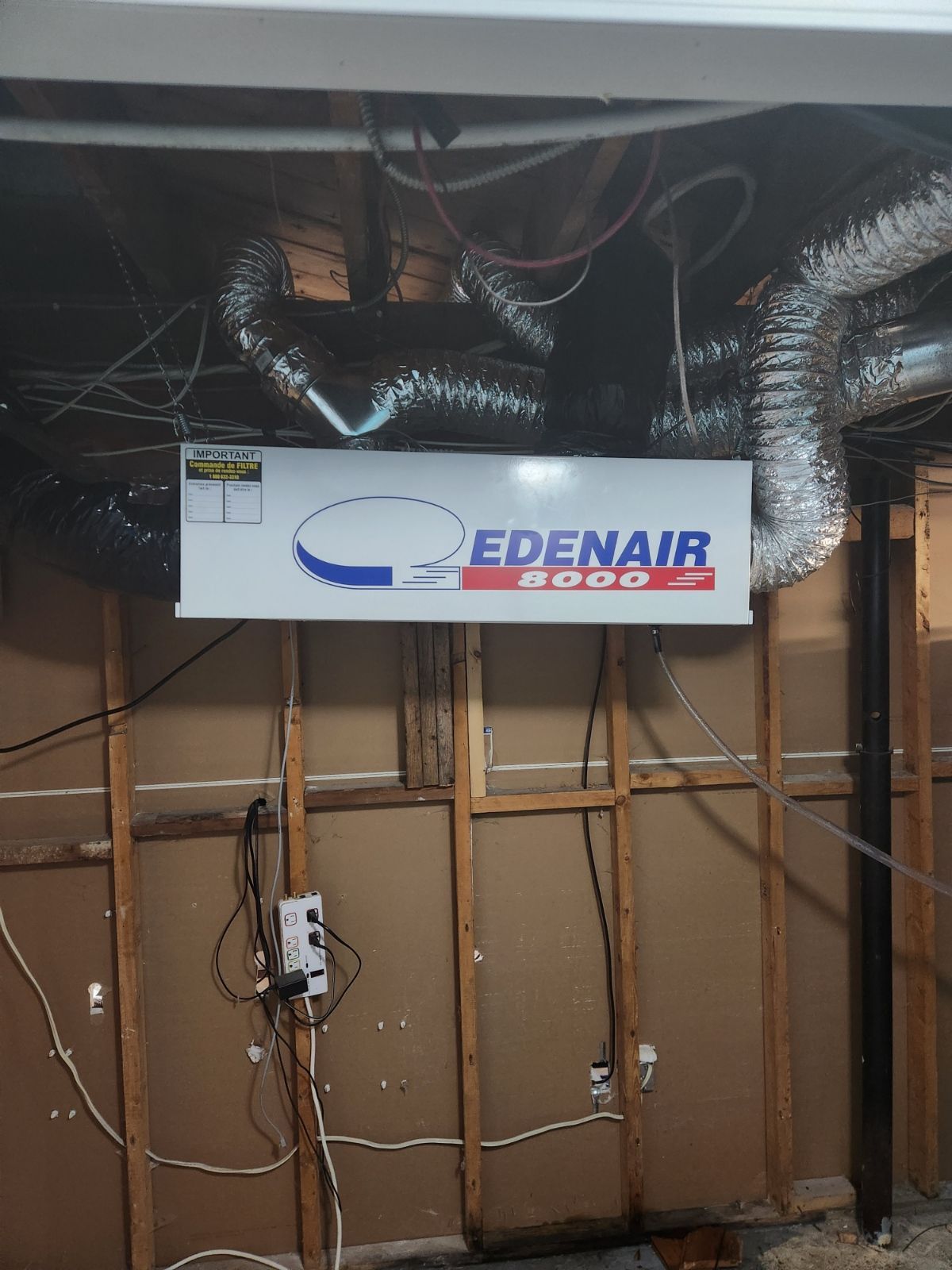 Un panneau indiquant Edenair est suspendu au plafond d'une pièce.