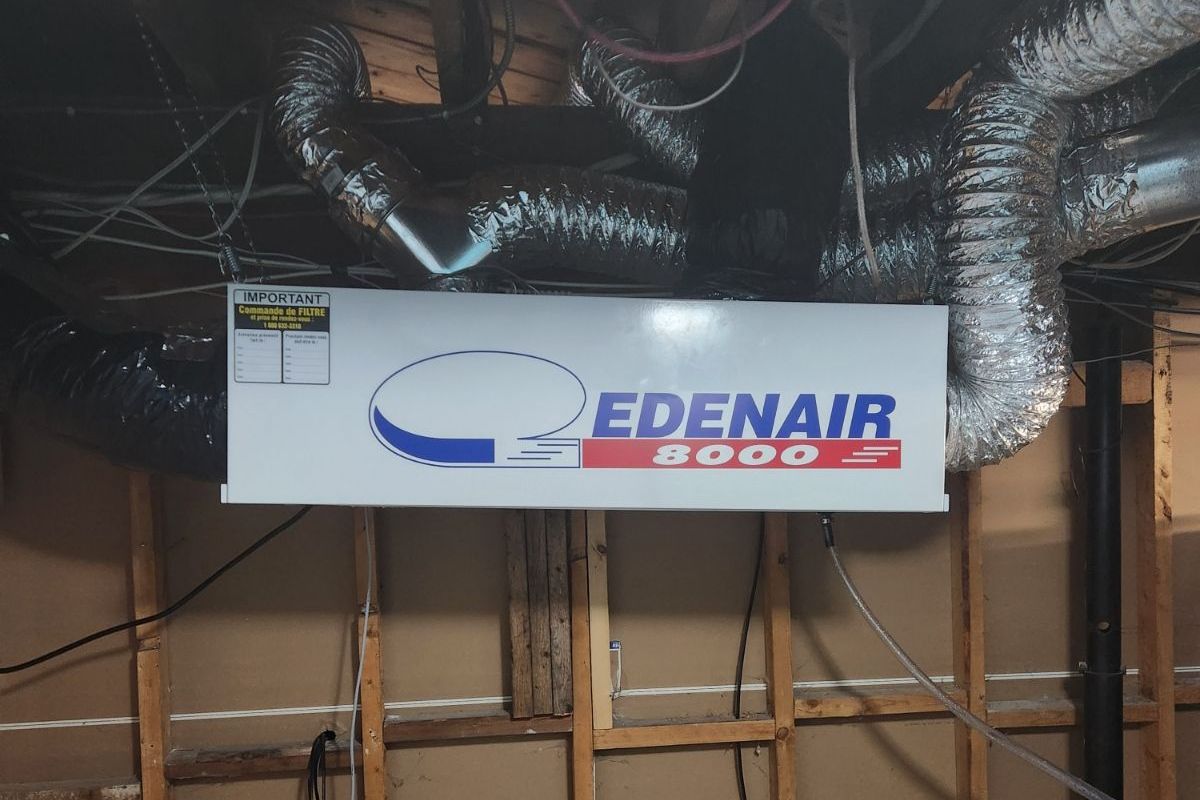 Un panneau Edenair blanc est suspendu au plafond d'une pièce