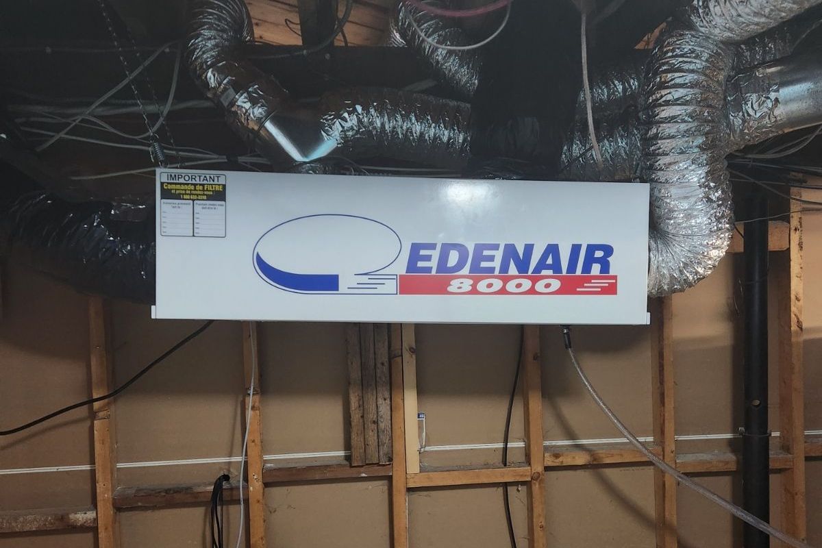 Un panneau blanc Edenair est suspendu au plafond d'une pièce.