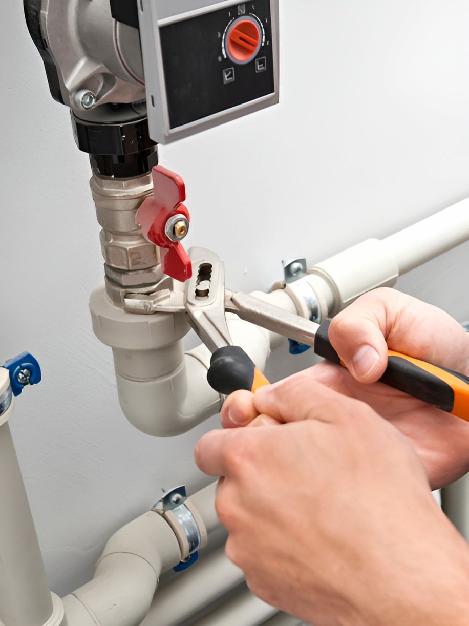 A Person Is Fixing A Pipe With A Wrench And Pliers — ARK Plumbing & Gasfitting In Exeter, NSW