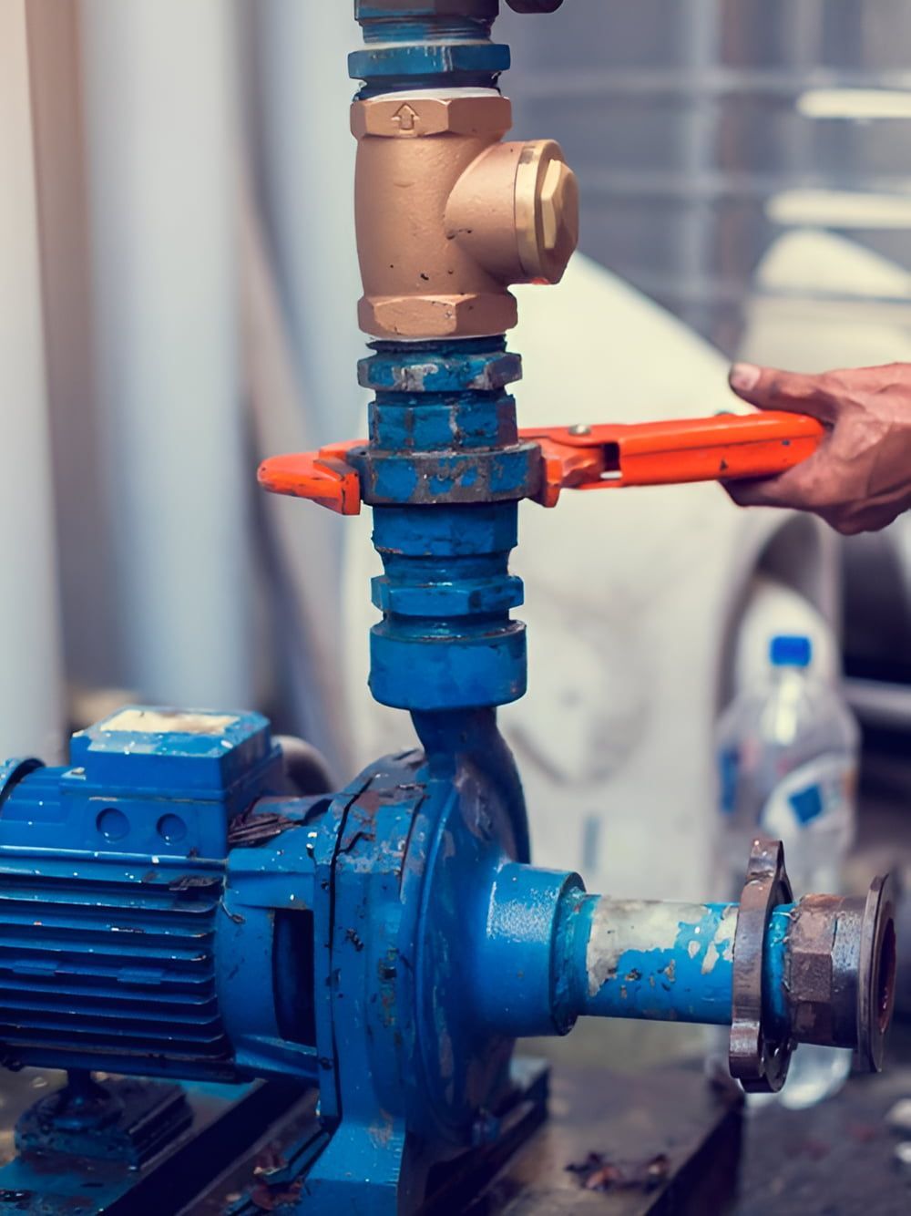 A Person Is Fixing A Water Pump With A Wrench — ARK Plumbing & Gasfitting In Mittagong, NSW