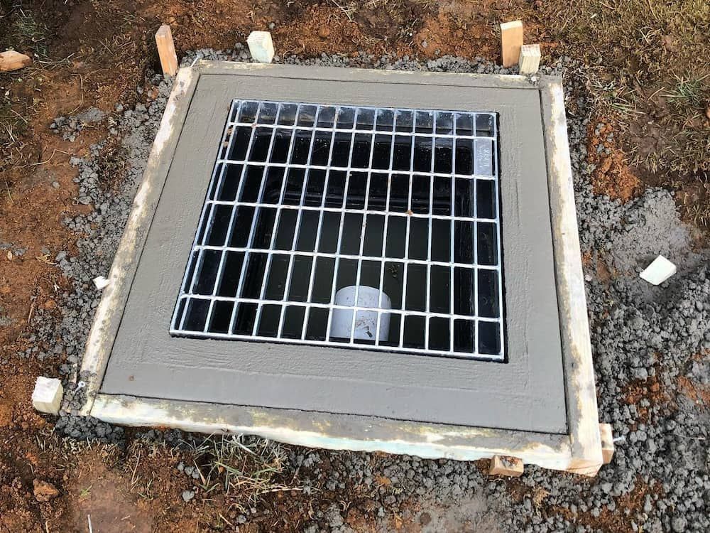 A Manhole Cover Is Sitting On Top Of A Concrete Slab — ARK Plumbing & Gasfitting In Mittagong, NSW