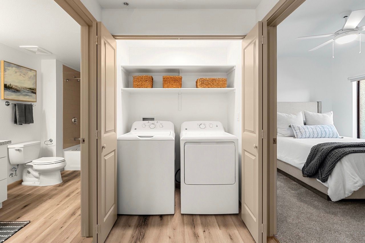 Laundry closet with a washer and dryer in a hall between the bathroom and bedroom.