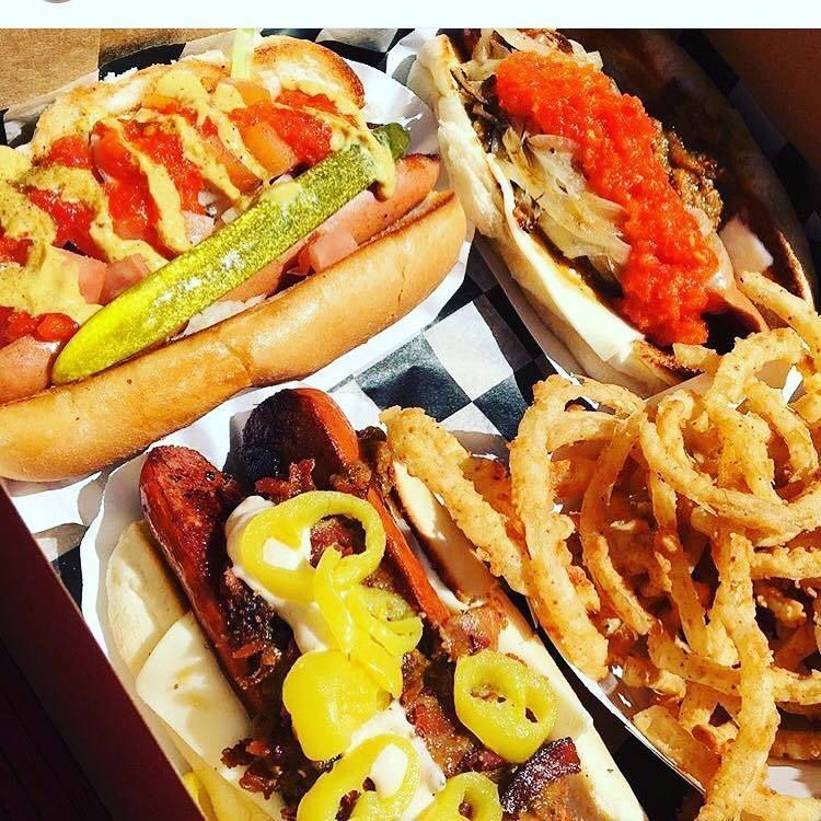 A bunch of hot dogs and onion rings in a box