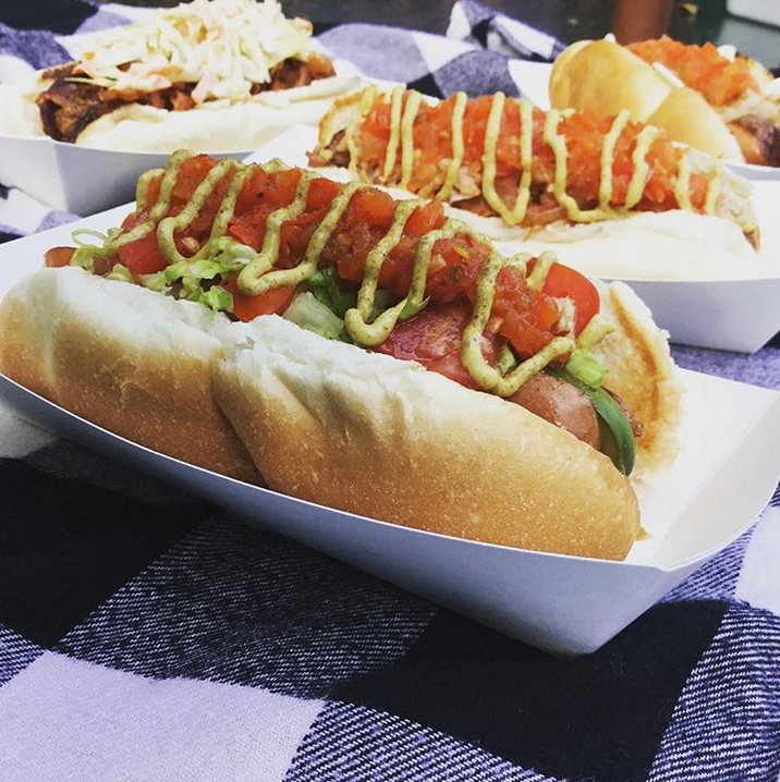 A bunch of hot dogs on a checkered table cloth