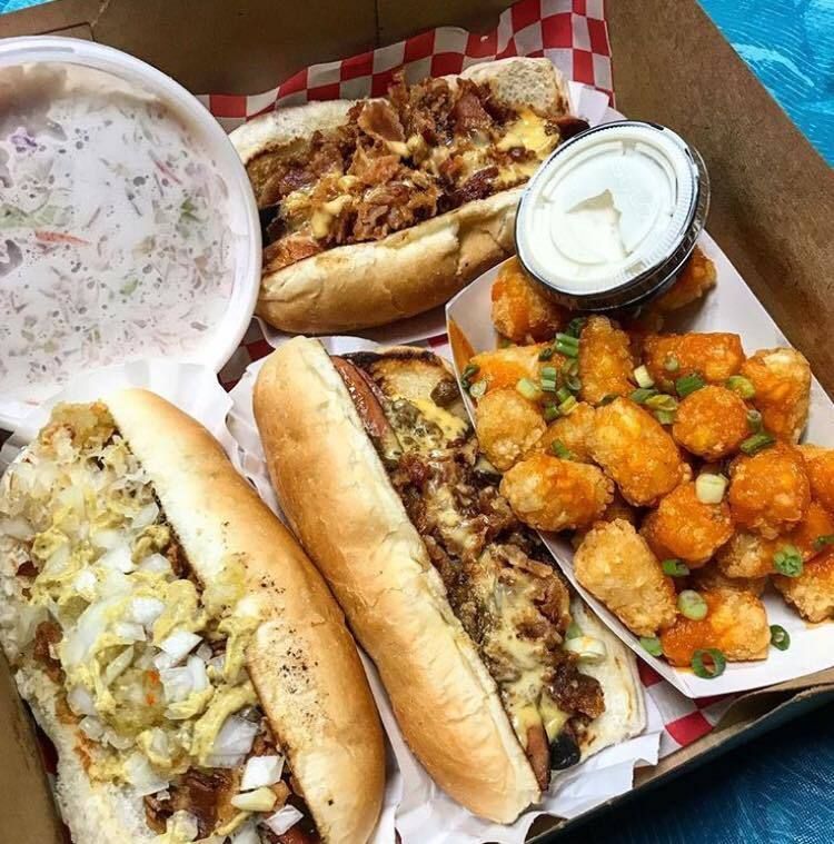 A box filled with a variety of food including hot dogs and tots