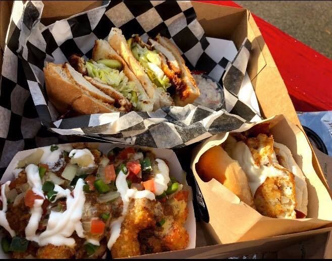 A box filled with a variety of food including sandwiches and hot dogs