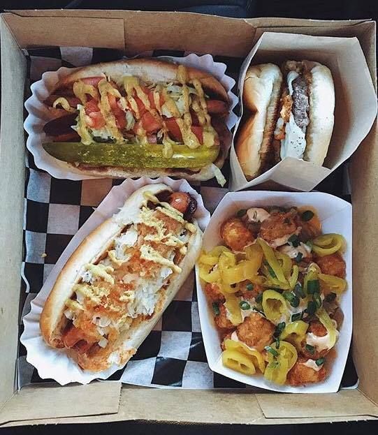 A box of hot dogs and a bowl of peppers